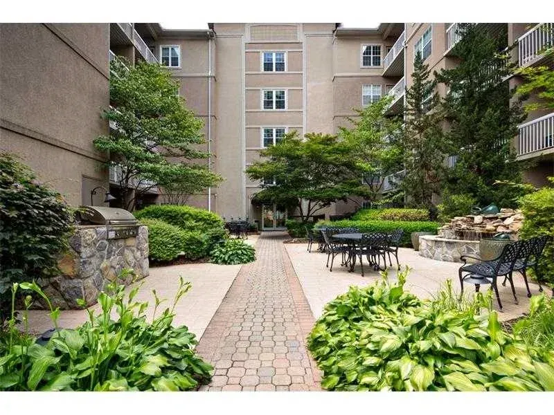 The landscaped A-Building courtyard with a stone grill, café seating, and a water feature