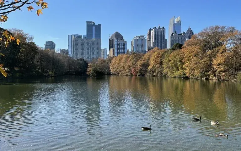 The Midtown skyline mirrored across the lake in Piedmont Park